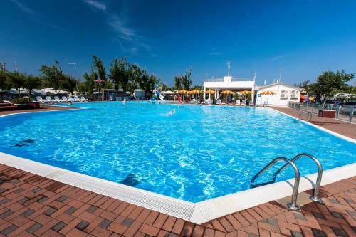 duży niebieski basen z ludźmi w nim w obiekcie Camping Tredue w mieście Sottomarina