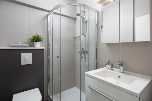 ein Bad mit einer Dusche und einem Waschbecken in der Unterkunft Apartments Zulijani House Helis B1 & B6 in Rabac