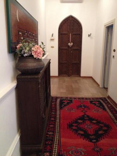 a hallway with a door and a vase with flowers on it at Ca' Dei Polo in Venice