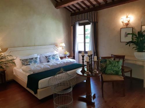a bedroom with a bed and a table and a window at I giardini segreti di Villa Marcello Marinelli in Cison di Valmarino