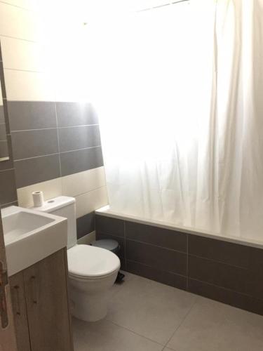 a bathroom with a toilet and a sink and a tub at Niro Apartments in Polis Chrysochous