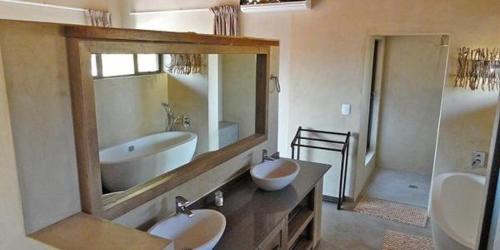 ein Badezimmer mit zwei Waschbecken und einem großen Spiegel in der Unterkunft Feeskraal Lodge in Moheme