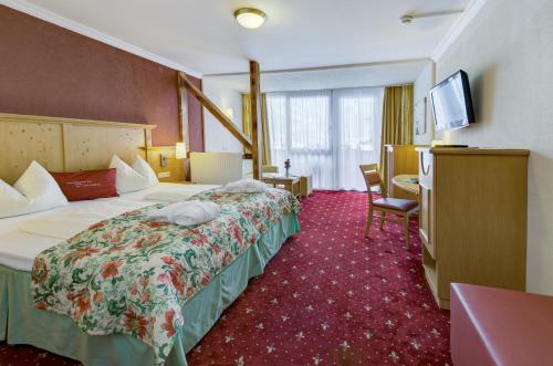 VÖTTER'S HOTEL in Kaprun - summer card included في كابرون: غرفة فندقية تحتوي على سريرين وتلفزيون بشاشة مسطحة