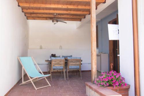 eine Terrasse mit einem Tisch, Stühlen und einer Decke in der Unterkunft La Spiaggetta Fontane Bianche in Fontane Bianche