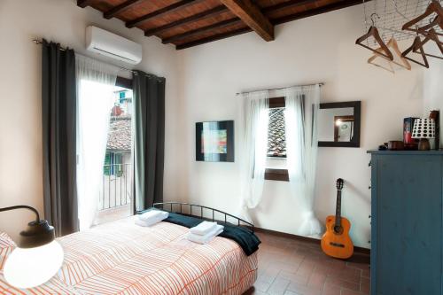 ein Schlafzimmer mit einem Bett und einer Gitarre in einem Zimmer in der Unterkunft Authentic flat in the city center in Florenz