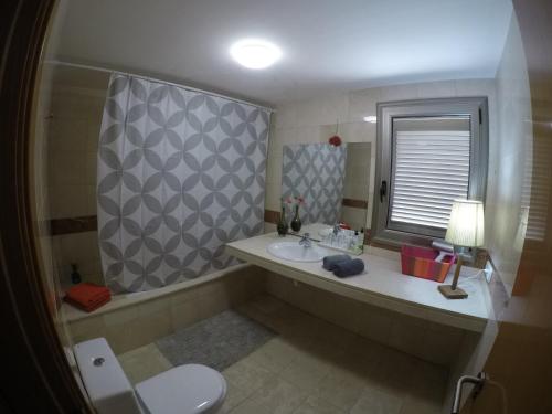 a bathroom with a sink and a toilet and a window at Vv Vistamar in Santa Cruz de Tenerife