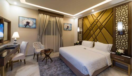 ein Hotelzimmer mit einem großen Bett und einem Schreibtisch in der Unterkunft Boudl Quraish in Dschidda