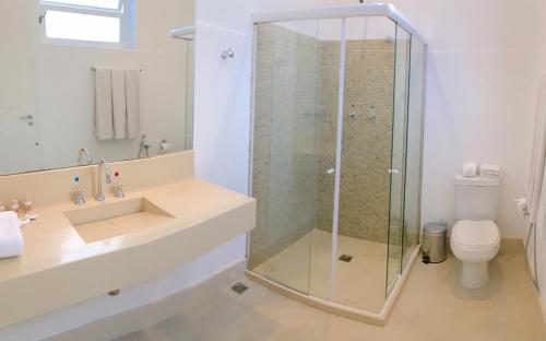 ein Bad mit einer Dusche, einem Waschbecken und einem WC in der Unterkunft Hotel Casablanca Imperial in Petrópolis