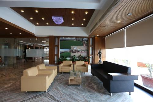a lobby with a couch and a piano at SilverCloud Hotel and Banquets in Ahmedabad