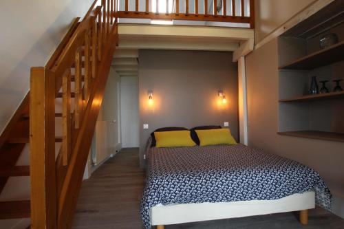 a bedroom with a bed with yellow pillows and a staircase at Ferme Ithurburia in Saint-Michel