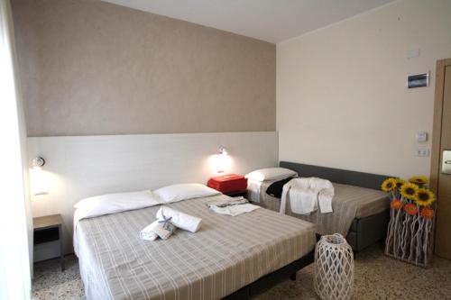 Dos camas en una habitación de hotel con toallas. en Hotel Tosi, en Riccione