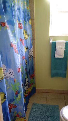 a bathroom with a shower curtain and a toilet at Atlantic Sands Beach Suites in Hollywood