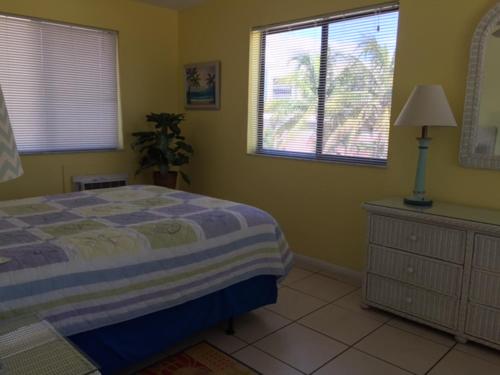 a bedroom with a bed and a dresser and windows at Atlantic Sands Beach Suites in Hollywood
