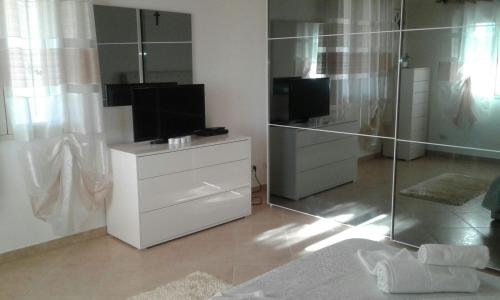 a room with a white dresser with a television and a mirror at Da Delfo in Agnone Bagni