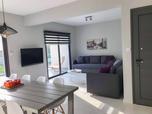 a living room with a table and a couch at Mare Monte Seaview Boutique Apartment in Paphos