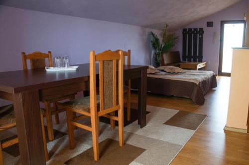 a dining room with a table and chairs and a bed at Pensiunea Nicol in Valea Iasului