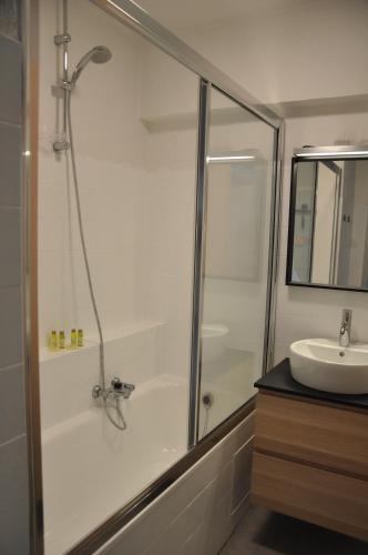 een badkamer met een douche en een wastafel bij Place 2 SEA - Appartement frontaal zeezicht - strand - Zeedijk - nabij Brugge in Blankenberge