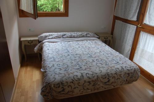 a small bed in a room with a window at 1 Carrer de la Carrerada in Esterri d'Àneu