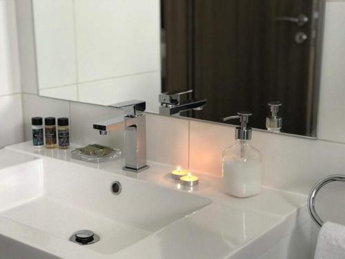 a bathroom with a white sink with a mirror at Mare Monte Seaview Boutique Apartment in Paphos