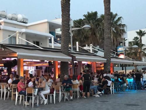 a group of people sitting in chairs at a restaurant at Mare Monte Seaview Boutique Apartment in Paphos