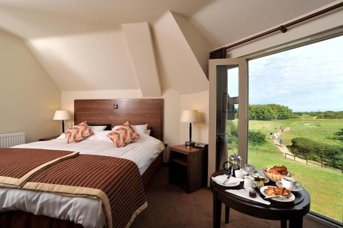 ein Schlafzimmer mit einem Bett und einem großen Fenster in der Unterkunft Thorpeness Golf Club and Hotel in Thorpeness