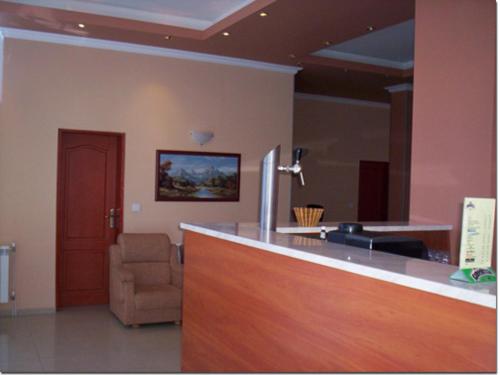 een woonkamer met een bar en een stoel bij Albatros 2 Family Hotel in Kiten
