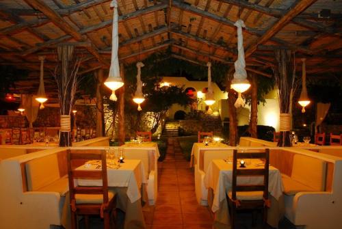 um restaurante com mesas brancas, cadeiras e luzes em Grand Hotel Santa Domitilla em Ponza
