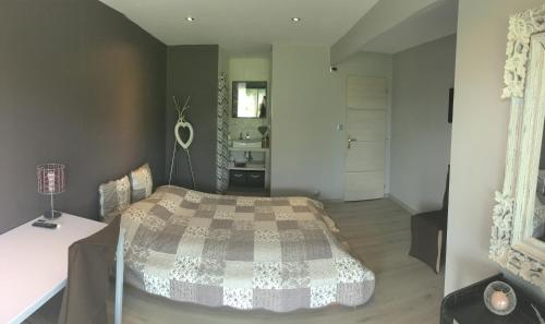 a bedroom with a bed and a table in a room at Safranière des Sorgues in Le Thor