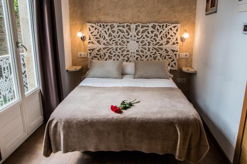 a bedroom with a bed with a flower on it at Casa da Balconada in Santiago de Compostela