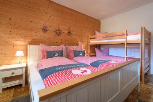 a bedroom with a bunk bed with pink and blue pillows at Haus Marieus in Umhausen