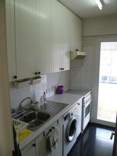 a kitchen with a sink and a washing machine at Double room with ensuite bathroom at Datacom building in Nicosia