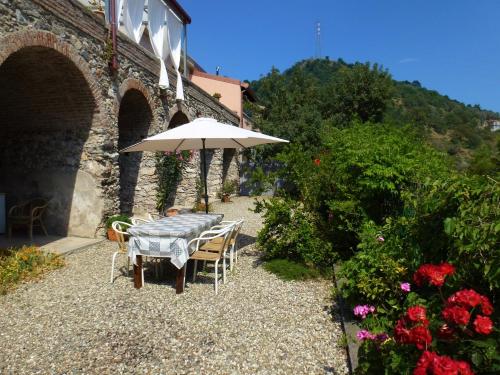 a table and chairs with an umbrella next to a building at Casale Praia in Letojanni