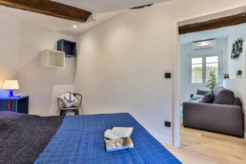 - une chambre avec un lit bleu et un canapé dans l'établissement MY CASA - LA CIVETTE, à Nice