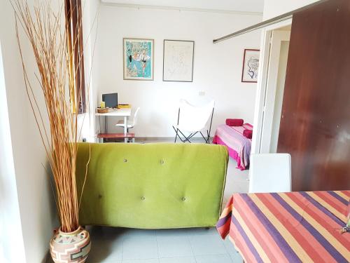 ein grünes Sofa in einem Zimmer mit einem Schlafzimmer in der Unterkunft Loft Plaça Sant Josep in Girona