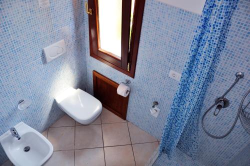 W łazience znajduje się toaleta, umywalka i prysznic. w obiekcie Villa Niko w mieście Costa Paradiso
