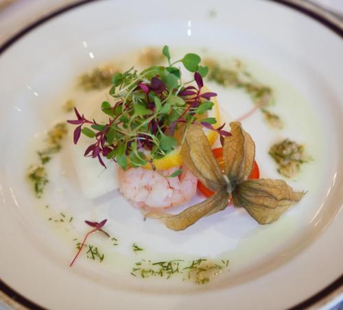 a plate of food with shrimp and greens on it at Garvock House Hotel in Dunfermline