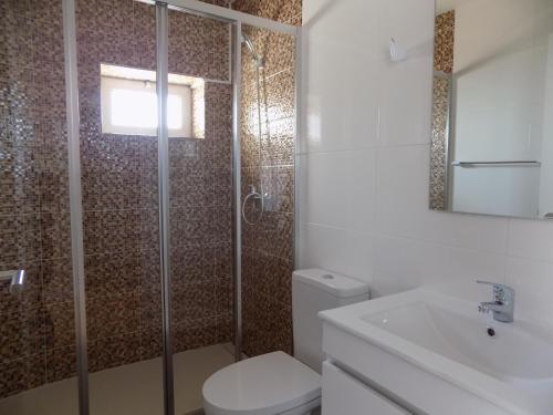 uma casa de banho com um chuveiro, um WC e um lavatório. em CMB Guesthouse em Apúlia