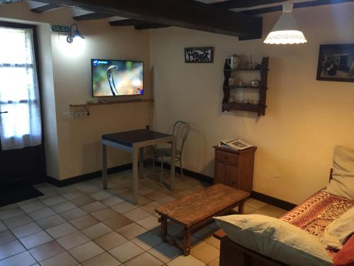 a living room with a table and a tv on the wall at Rincón de Altikarra in Undiano