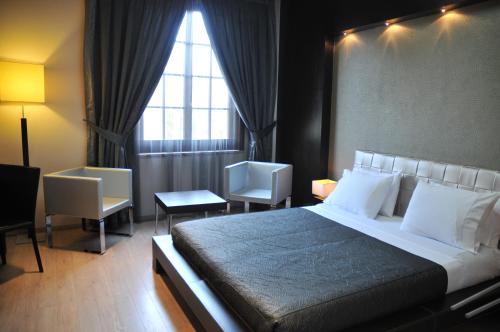 a bedroom with a large bed and a window at MonarC Hotel in Tirana