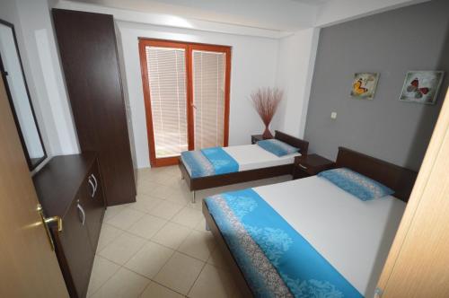 a small room with two beds and a window at Nikolic Apartments - Ohrid City Centre in Ohrid