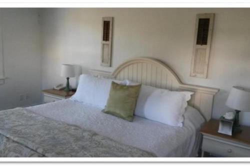 a bedroom with a bed with white pillows and two lamps at Newagen Seaside Inn in Southport