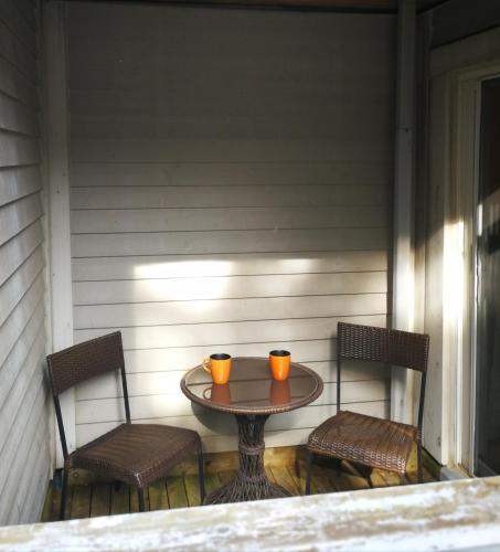 two orange cups sitting on a table on a porch at Rustic Mountainside Chalet in Blue Mountains