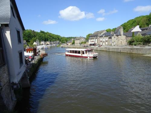 a boat traveling down a river in a town at Mahe in Plancoët