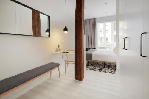Schlafzimmer mit einem Bett, einem Tisch und einem Spiegel in der Unterkunft Bilbao Plaza by FeelFree Rentals in San Sebastián