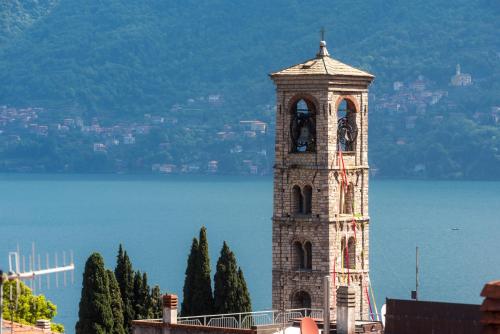 a clock tower in front of a body of water at Appartamento Persico - Lake view and private parking in Torno