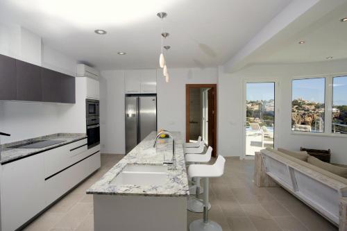 a kitchen with white cabinets and white counter tops at Blue Dream Villa in Jávea