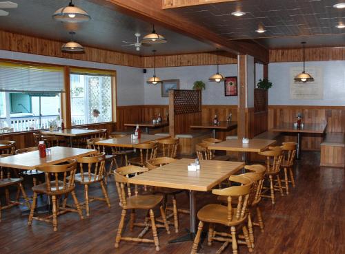 una sala da pranzo con tavoli e sedie in legno di Triple J Hotel a Dawson City