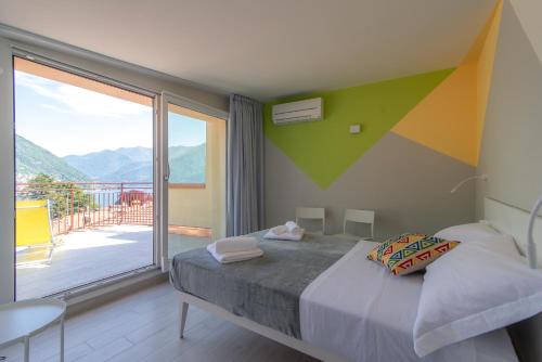 a bedroom with a bed and a large window at Appartamento Persico - Lake view and private parking in Torno