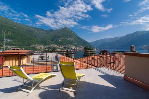two chairs on a balcony with a view of the mountains at Appartamento Persico - Lake view and private parking in Torno