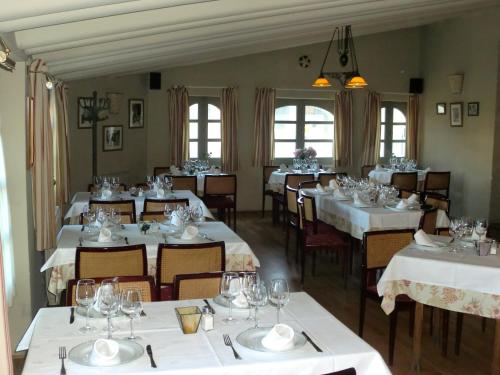 un comedor con mesas y sillas blancas en Hotel Roma, en La Granja de San Ildefonso